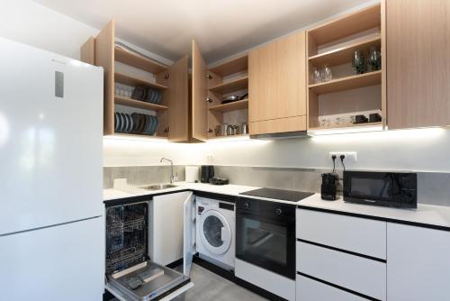 a kitchen with white cabinets and a washer and dryer at Semeli Lux apt, Siviri in Siviri