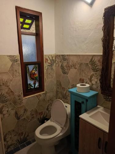 a bathroom with a toilet and a sink and a window at Usaquen Casa vintage La flor del callejon in Usaquén