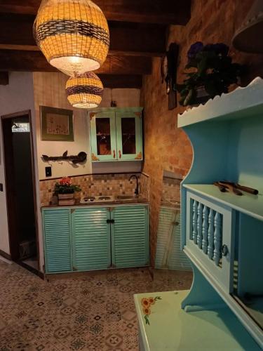 a kitchen with green cabinets and a chandelier at Usaquen Casa vintage La flor del callejon in Usaquén