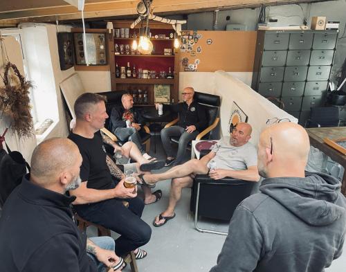 a group of men sitting in a room at Bikes Beers Bed and Breakfast 