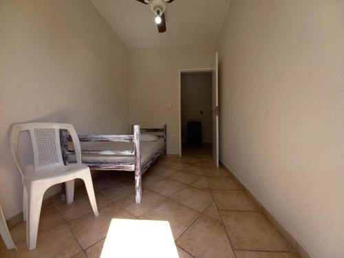 a room with a bed and a chair in it at Chalés Caraguá Massaguaçu in Caraguatatuba