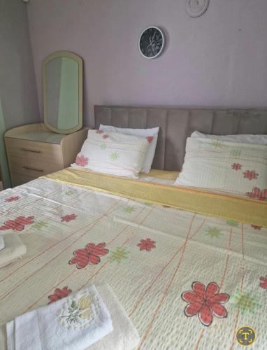 une chambre avec un lit avec une couverture fleurie et un miroir dans l'établissement Marija Apartment br 1, à Bitola
