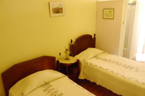 a bedroom with two beds and a window at Residencial Luz in Tomar