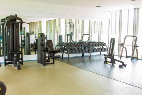 a gym with rows of exercise equipment in a room at The Lennox- one bedroom in Trofwi