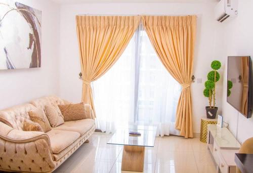 a living room with a couch and a large window at The Lennox- one bedroom in Trofwi