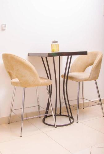 a black table with two chairs and a black table with at The Lennox- one bedroom in Trofwi