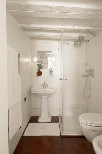 a white bathroom with a sink and a toilet at Ca Dadda terrace at Rialto Bridge -historic residence equipped with all comforts in Venice