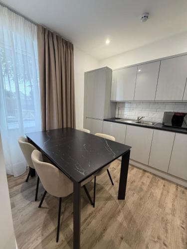 a kitchen with a black table and chairs in a room at Luxury Sovereign House in Brighouse