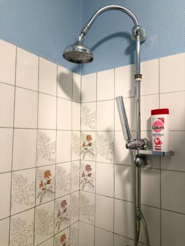 La salle de bains est pourvue d'une pomme de douche et de carrelage blanc. dans l'établissement Casa Thiaza - Close to Orly - 6 people - 3 bedrooms, à Thiais