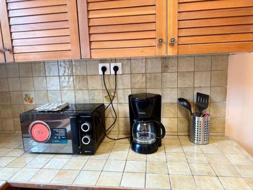 a microwave on a kitchen counter with a coffee maker at Casa Thiaza - Close to Orly - 6 people - 3 bedrooms in Thiais