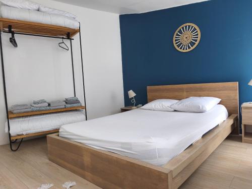 a bedroom with a bed and a clock on the wall at logement Cholet proche puydufou in Cholet