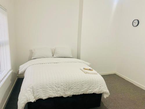 Un dormitorio con una cama con un edredón blanco. en Stylish Studio in Liverpool, en Liverpool