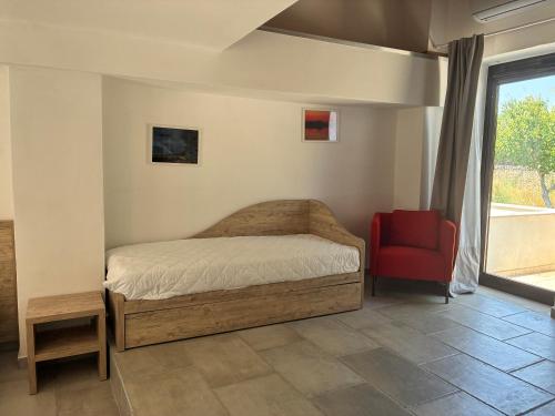 a bedroom with a bed and a red chair at Bosco Elda in San Giovanni Rotondo