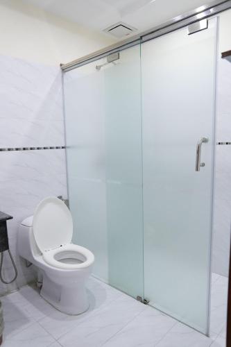 a bathroom with a toilet and a glass shower stall at Grand Millennium Hotel in Lahore