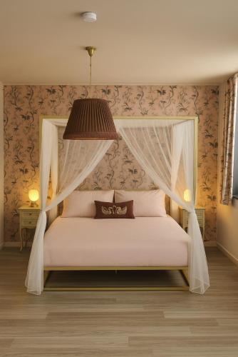 a bedroom with a white bed with a canopy at Coucou - luxe bed and breakfast in Wenduine