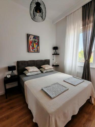 a bedroom with a large bed and a window at Lake Palić Apartment in Palić