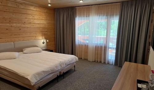 a bedroom with a bed and a large window at BAYKA - SPA resort in Kosiv