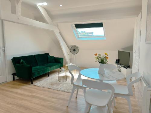 un soggiorno con un divano verde e un tavolo di Le Chic Nest à Orléans - Appartement 2 chambres - proche ligne de Tramway et gares a Orléans