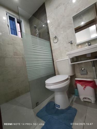 a bathroom with a toilet and a glass shower at Housing Staci in Santo Domingo