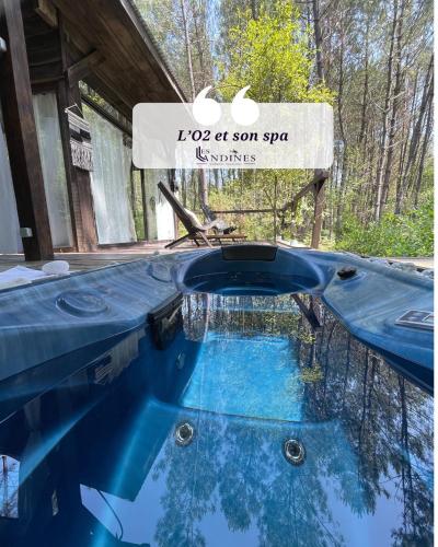a swimming pool with a sign on top of it at L'O2 et son Spa, cabane de verre et de bois in Origne