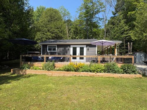 a small house with a fence and an umbrella at Peninsula Perch in Wiarton