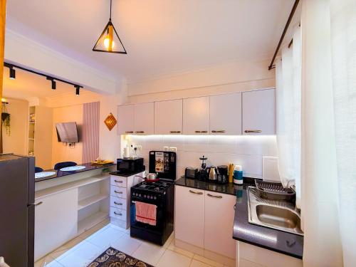 a kitchen with white cabinets and a black stove at Ngong Hills View in Ngong