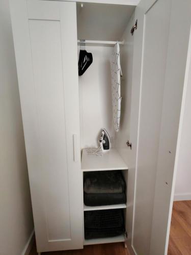 a walk in closet with white walls and shelves at Apartman Rakanović in Palić