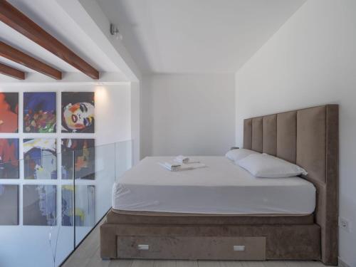 a bedroom with a bed with a wooden headboard at Seaview Villa with pool-Vanja in Budva