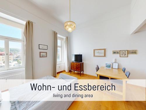 a living room with a table and a dining area at Salzkammergut Homes Gmunden - Suite Marie Antoinette, Blick auf den Stadtplatz, Traunseeblick - ideal für Paare und Kulturinteressierte in Gmunden