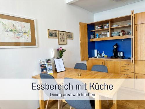 a dining area with kitchen in a living room with a wooden table at Salzkammergut Homes Gmunden - Suite Marie Antoinette, Blick auf den Stadtplatz, Traunseeblick - ideal für Paare und Kulturinteressierte in Gmunden