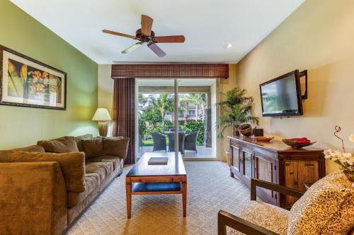 a living room with a couch and a tv at Castle Hali'i Kai at Waikoloa in Waikoloa