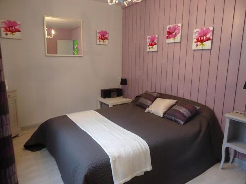 Un dormitorio con una cama grande con rayas rosas. en Chalet Vert 10 min walk to Argentat city center, en Argentat