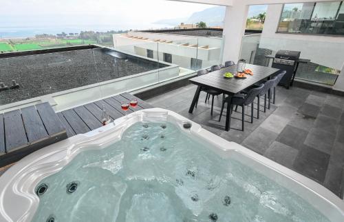 a jacuzzi tub on the roof of a house at Yalarent C Kinneret Apartments With Private Jacuzzi in Migdal