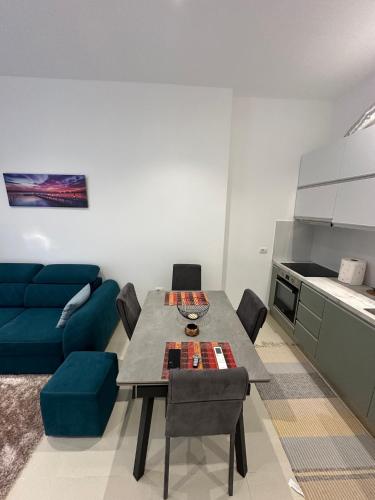 a living room with a table and a blue couch at Exlusive Home Golem in Golem
