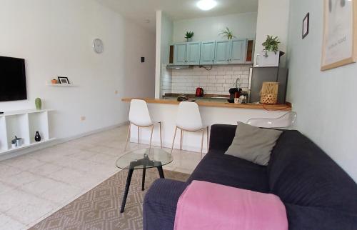 a living room with a couch and a kitchen at La Casita de Puerto in Puerto del Rosario