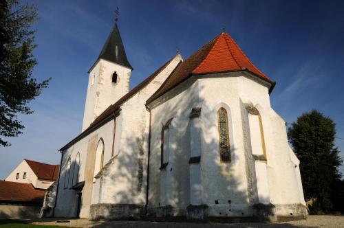 a church with an orange roof and a tower at Chonky Cat in Moravske Toplice