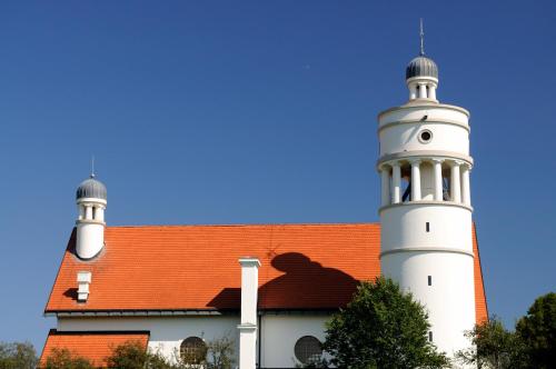 a building with two white towers and a red roof at Chonky Cat in Moravske Toplice