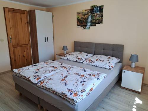 a bedroom with a bed with a floral comforter at Noclegi u Agnieszki in Jarnołtówek