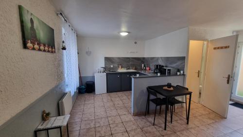 - une cuisine avec une table et un comptoir dans une pièce dans l'établissement T2 centre rénové 36 m2 confort !, à Charleville-Mézières
