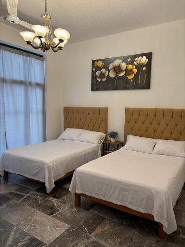 two beds sitting next to each other in a room at Rivadeneyra Hotel Boutique in Iguala de la Independencia