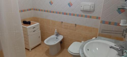 a bathroom with a white toilet and a sink at L'Aurora Corso Umberto l 220, 88821 Rocca di Neto in Rocca di Neto