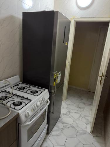 a kitchen with a stove and a sink and a door at Zac B Hosting in Mbaw