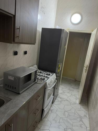 a kitchen with a stove and a microwave at Zac B Hosting in Mbaw