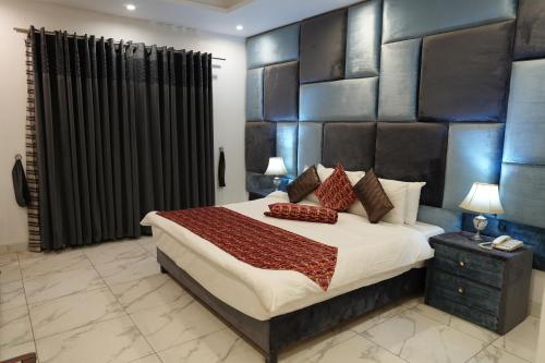 a bedroom with a large bed with a black headboard at Grand Millennium Hotel in Lahore