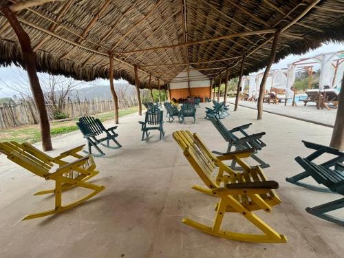 a group of lawn chairs sitting under a straw umbrella at Hotel Arena Beach Cartagena in Cartagena de Indias