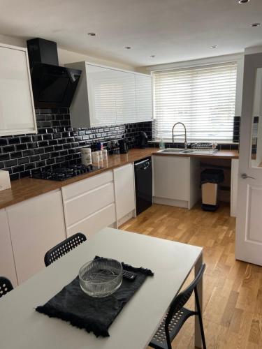 a kitchen with a white table and a counter top at Garland way 2 bed house Sheffield free parking 5 min from m1 in Mosborough
