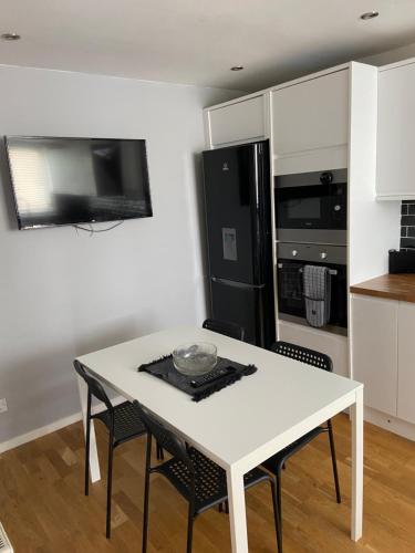 a kitchen with a white table and black appliances at Garland way 2 bed house Sheffield free parking 5 min from m1 in Mosborough