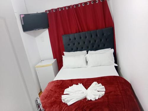 a bedroom with a bed with a red curtain at PEACEFUL SLEEP lodge 1 in Goodwood