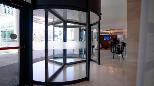 a glass door in a building with a table at Alliance Palace Seaside in Batumi