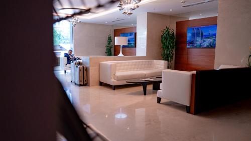a living room with a couch and a table at Alliance Palace Seaside in Batumi